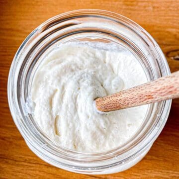 Sourdough starter being mixed with a wooden spoon.