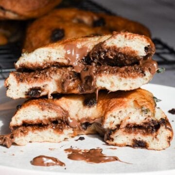 Chocolate chip sourdough bagel sandwich, cut in half and smeared with chocolate spread on a plate.