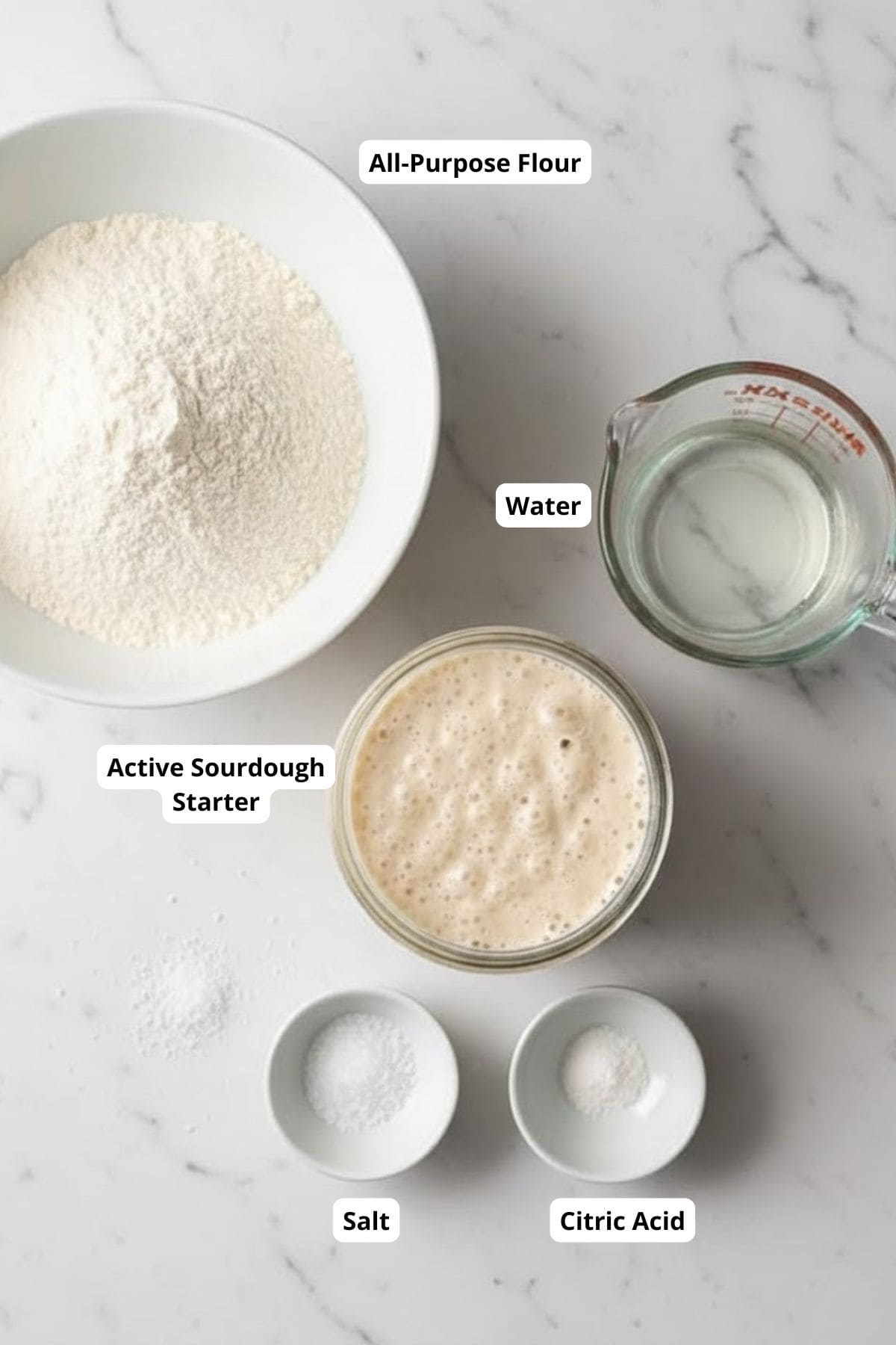 Ingredients for making the extra sour sourdough bread arranged in marble table top.