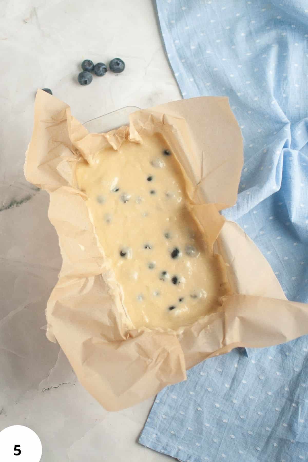 Blueberry lemon quick bread batter in parchment-lined pan for sourdough discard recipe.