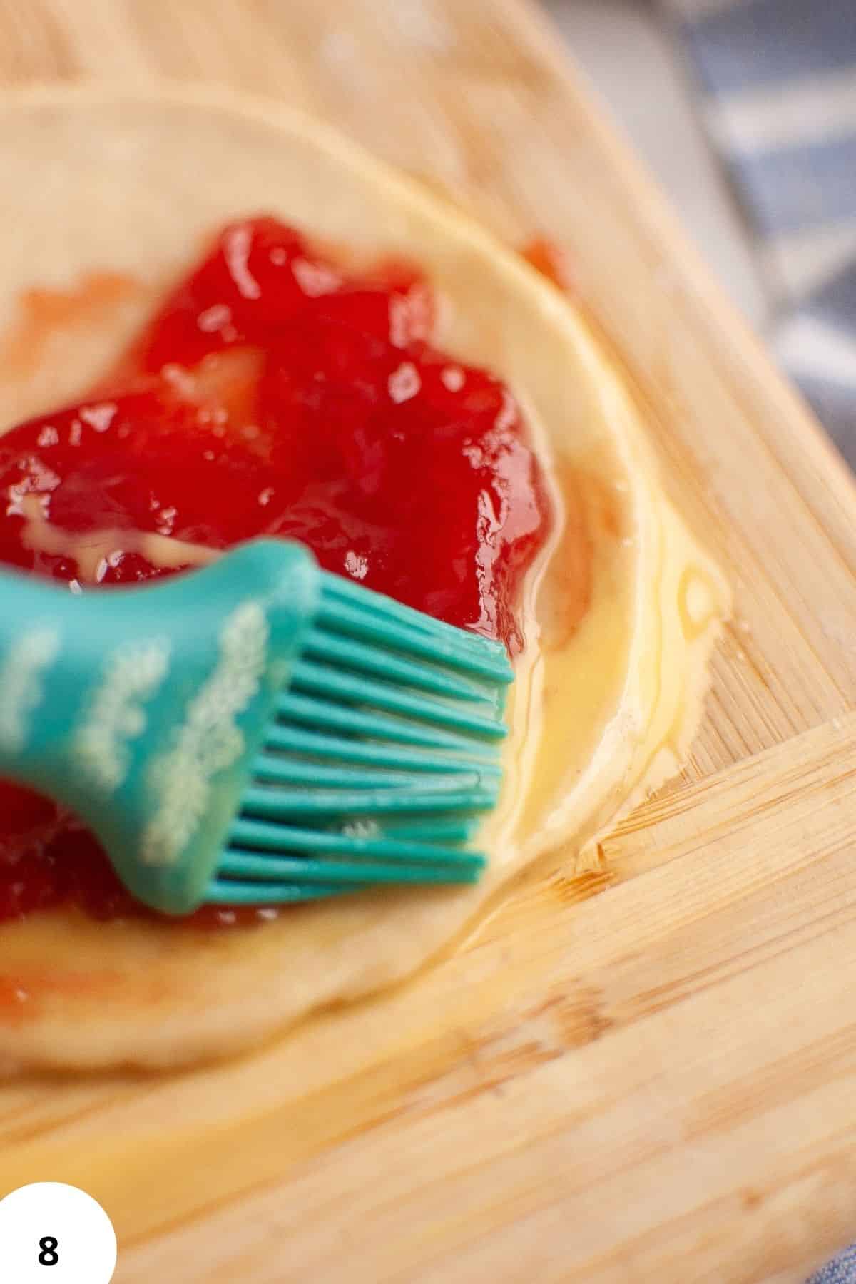 Demonstration of stretch and fold technique on sourdough dough with jam filling.