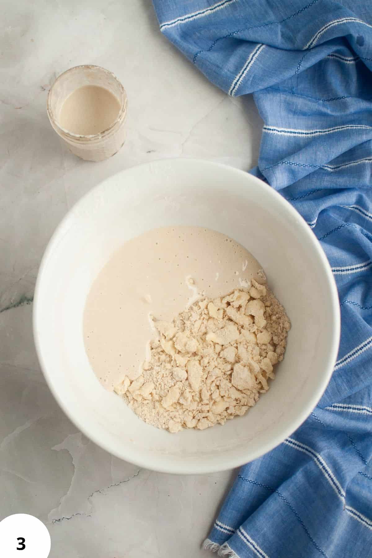 Sourdough starter and flour in a white bowl, ready for making savory spinach and feta hand pies.