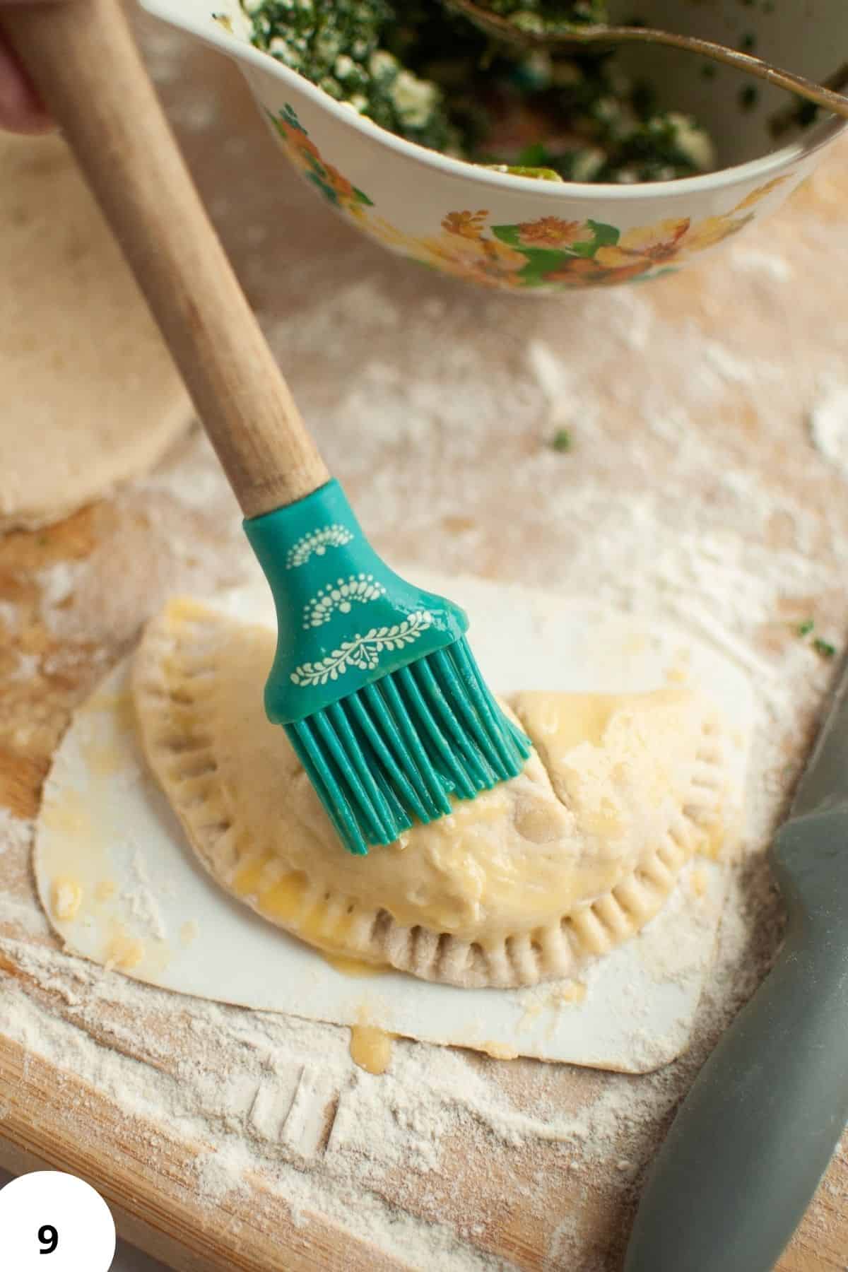 Sourdough pie being shaped with a brush on the dough, ready for baking.