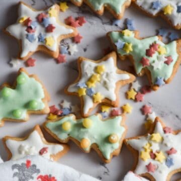 Festive sourdough cut-out cookies on a marble surface with a festive tea towel.