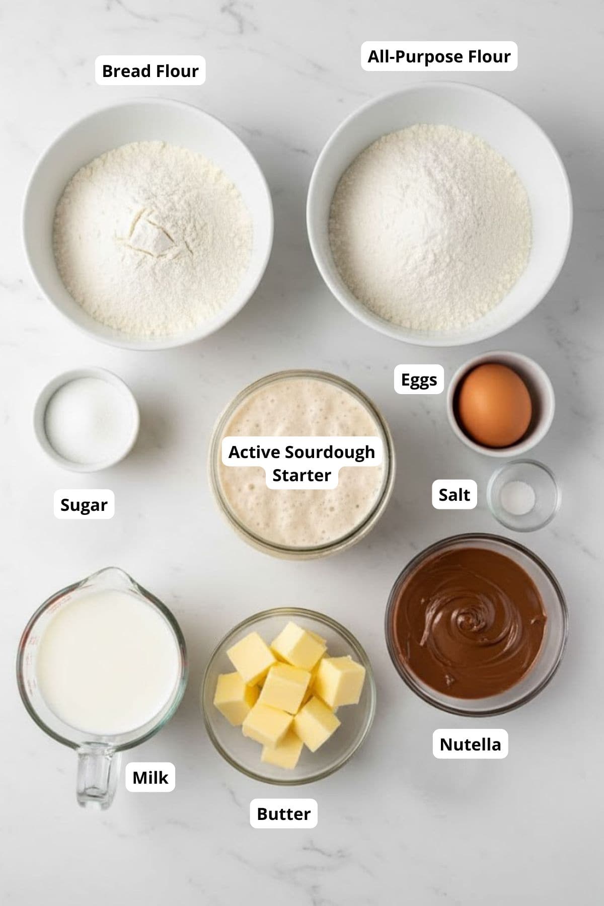 Ingredients for making the same day sourdough chocolate knots with nutella arranged in a marble top.