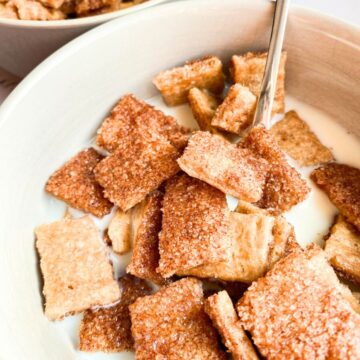 A bowl full of homemade cinnamon crunch cereal with milk.