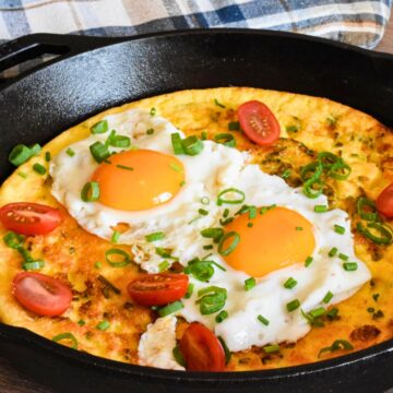 Eggs on dutch baby in a cast iron skillet.