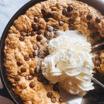 Whipped cream melting on a sourdough cookie skillet.