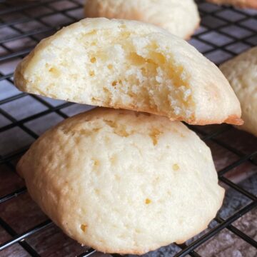 Sourdough vanilla wafer on top of other cookie, with a bite take out of it.
