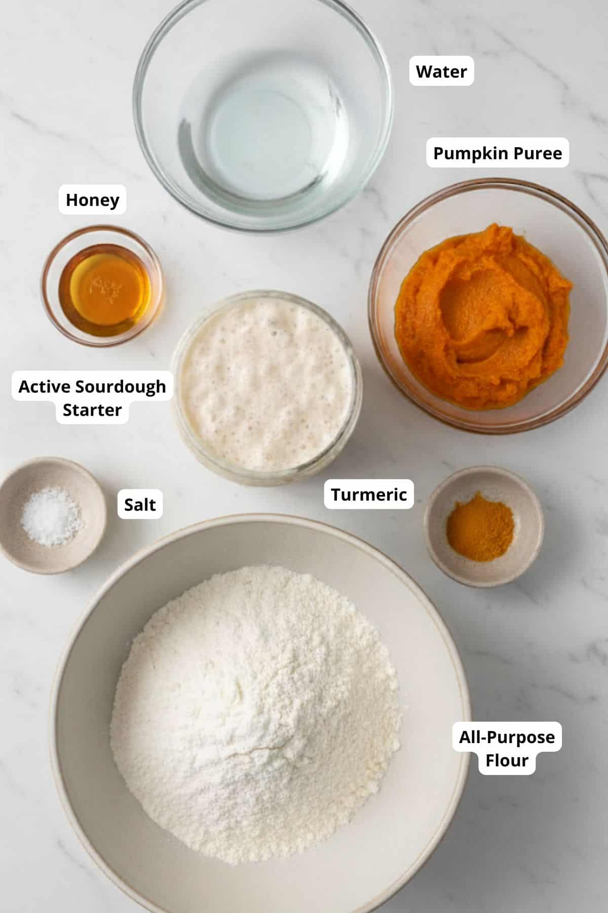 Ingredients for sourdough pumpkin bread arranged neatly on a surface.