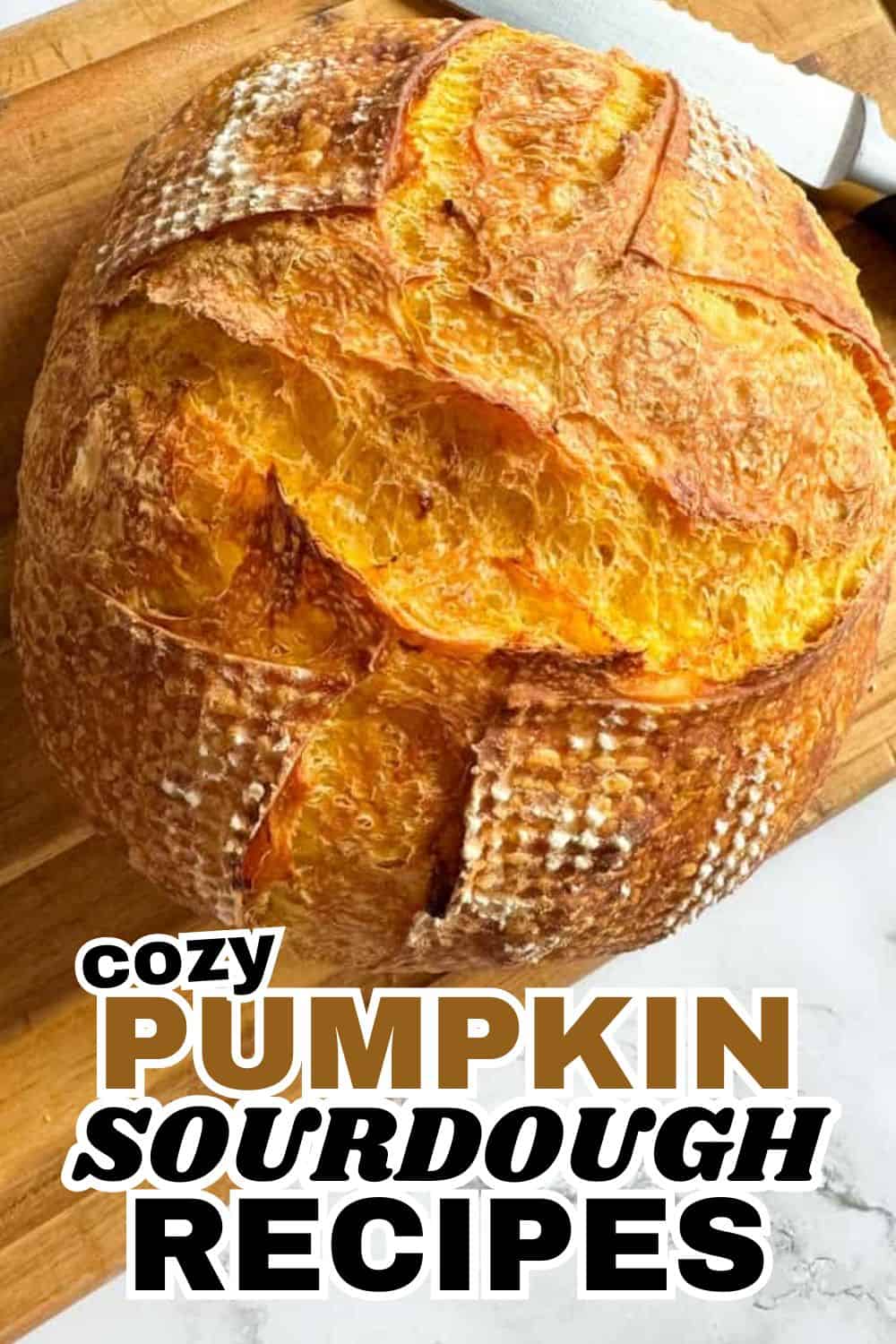 Fresh pumpkin sourdough bread with a crispy crust on a wooden board.
