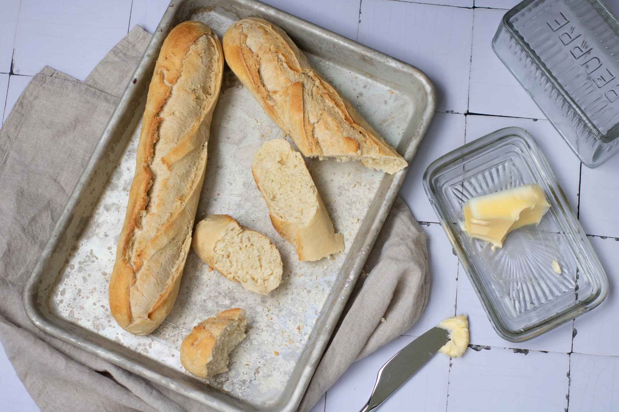 Sliced French Baguette with butter in a baking tray.