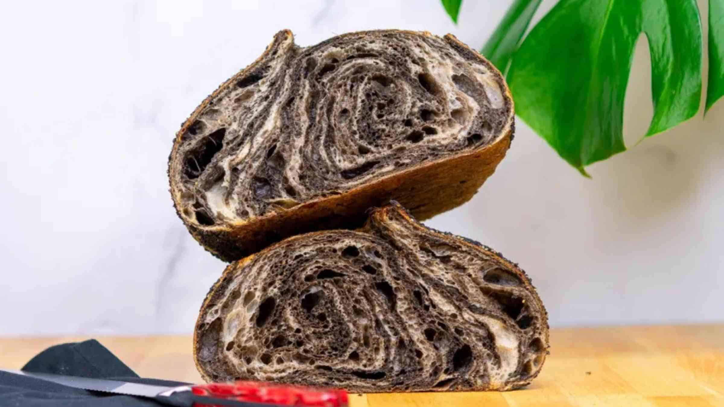 Black sesame sourdough bread on a wooden board.