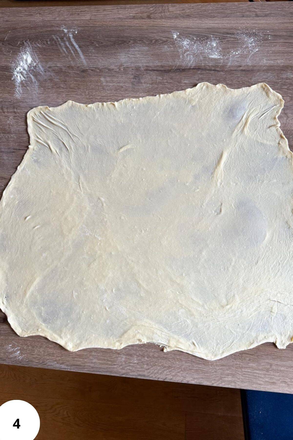 Stretched dough on a floured table.