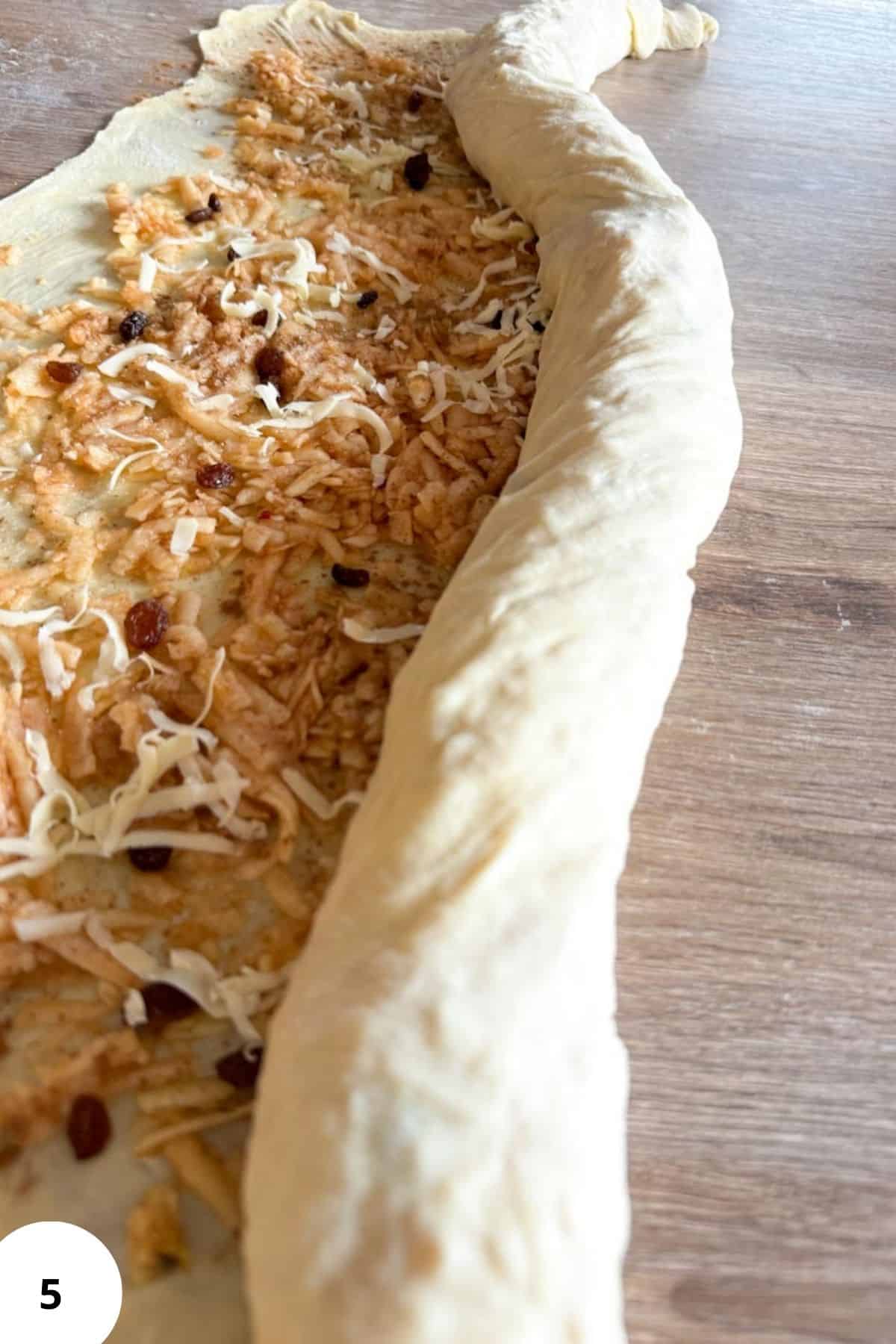 A half rolled roll of apple strudel.