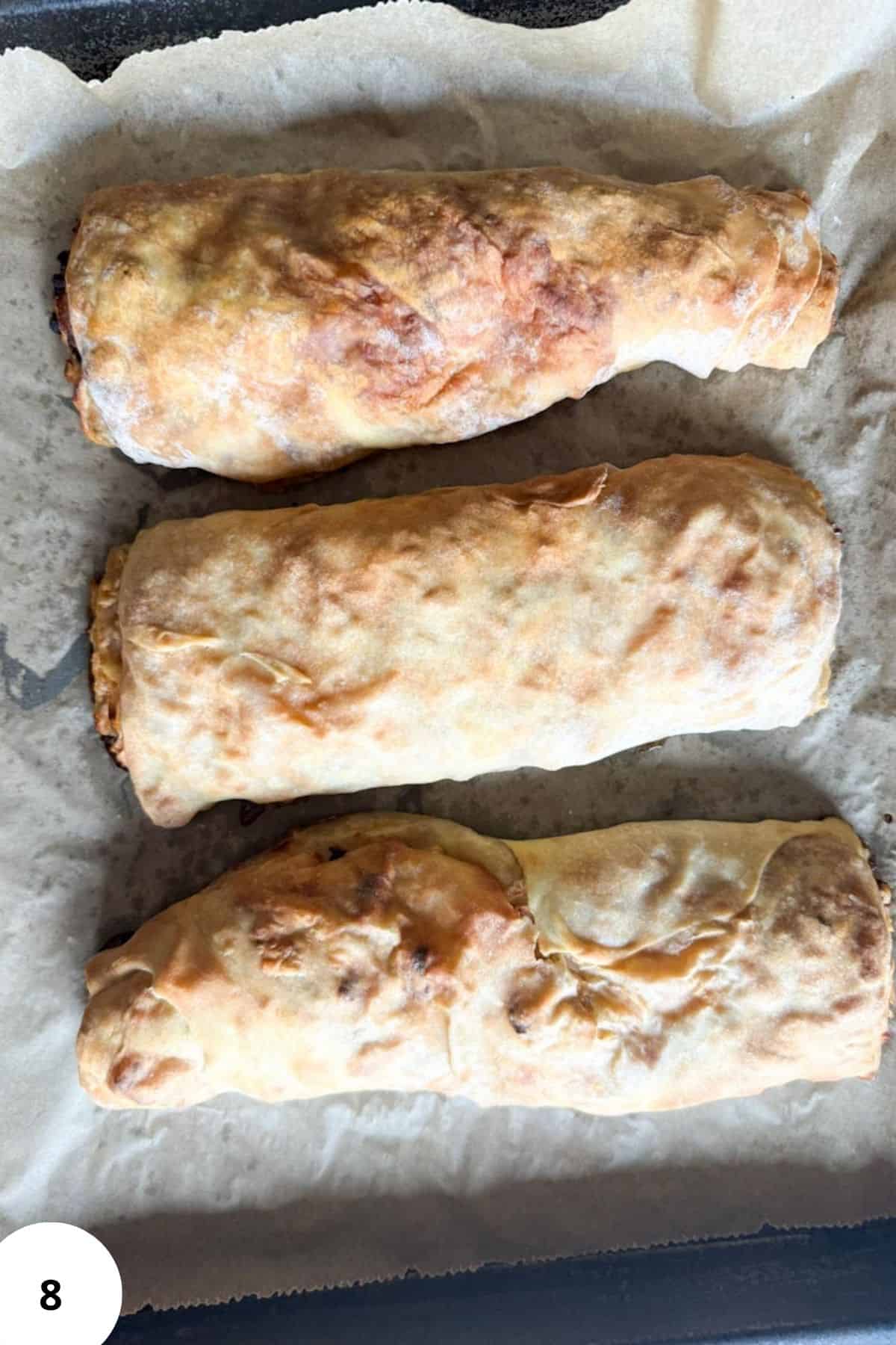 Apple strudel rolls on a cookie sheet.