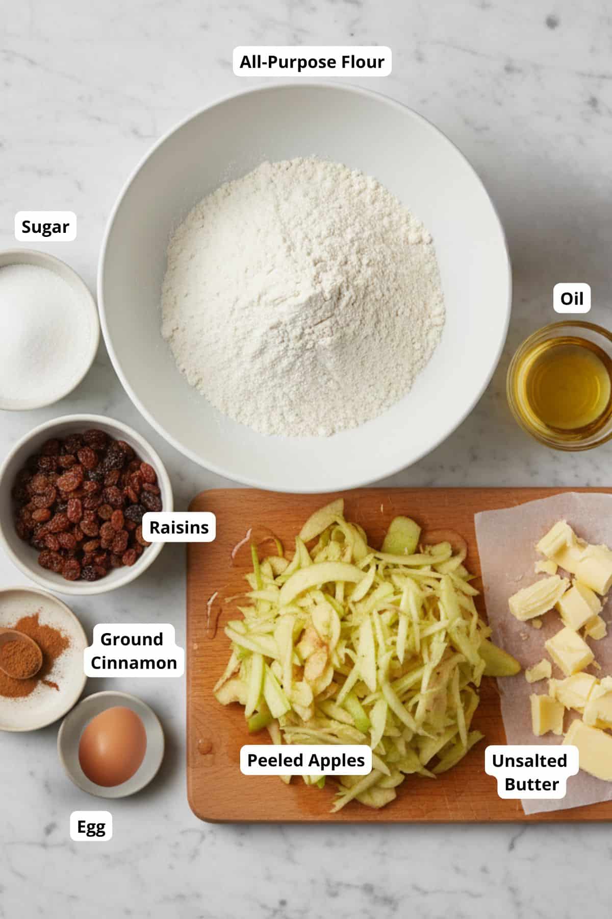 Ingredients for a traditional apple strudel recipe neatly arranged on a surface.