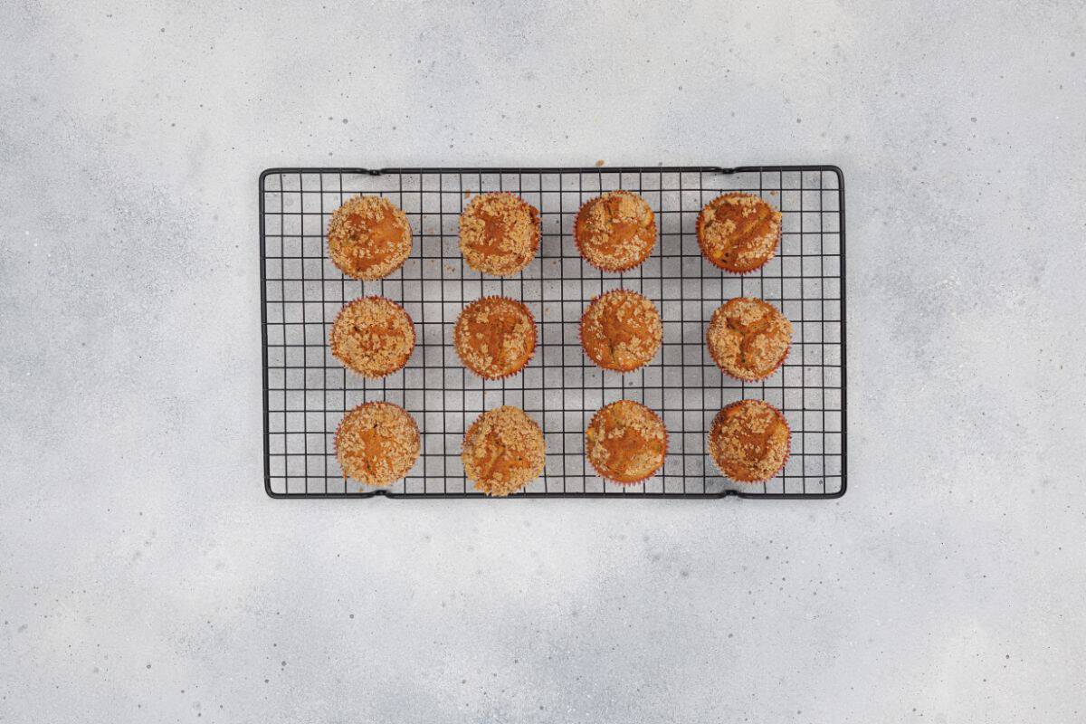 Freshly baked apple cinnamon muffins cooling on a wire rack.