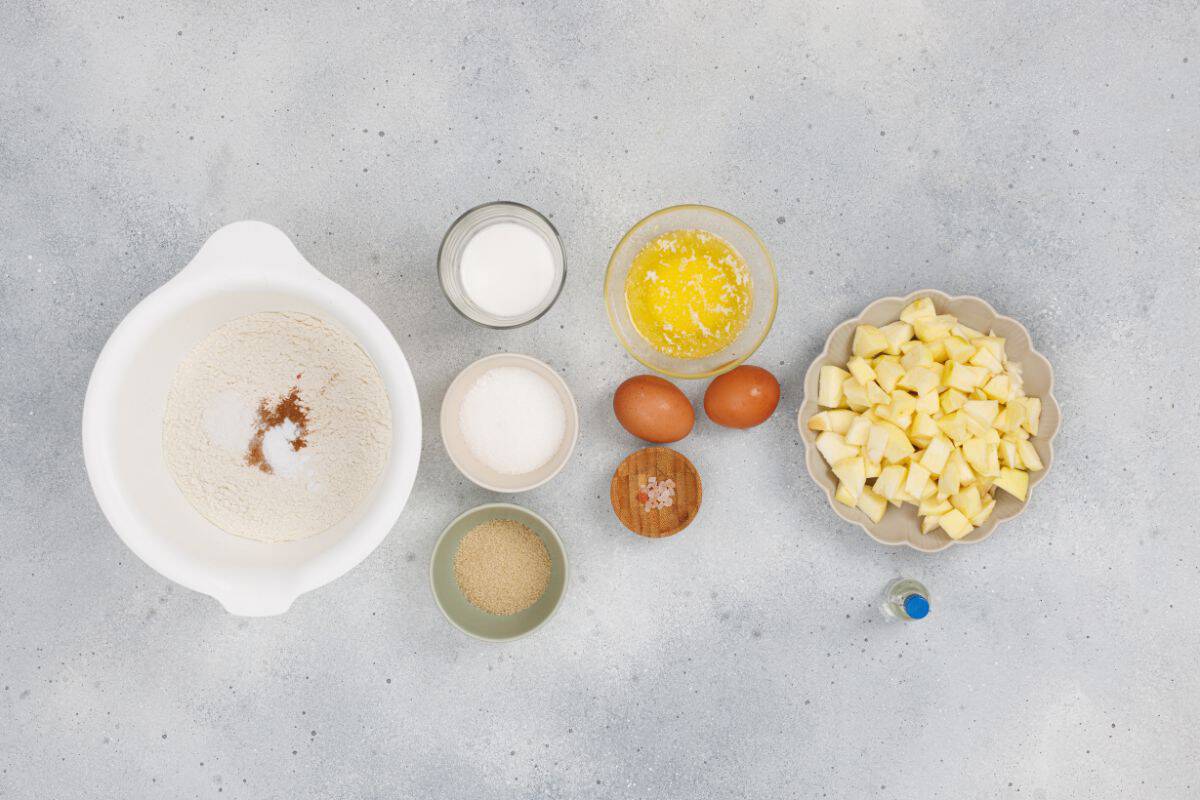 Ingredients for apple cinnamon muffins on a surface.