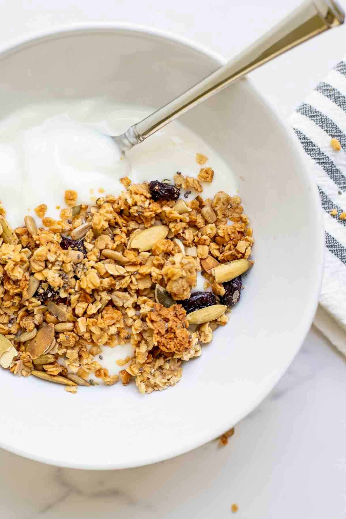 A bowl of crispy sourdough granola with nuts and dried fruit.
