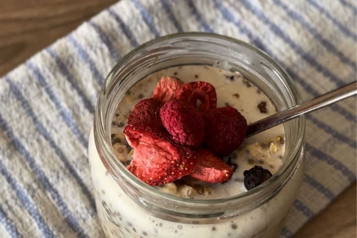 Overnight oats in a jar, topped with fresh berries and a sprinkle of extra dried fruit.