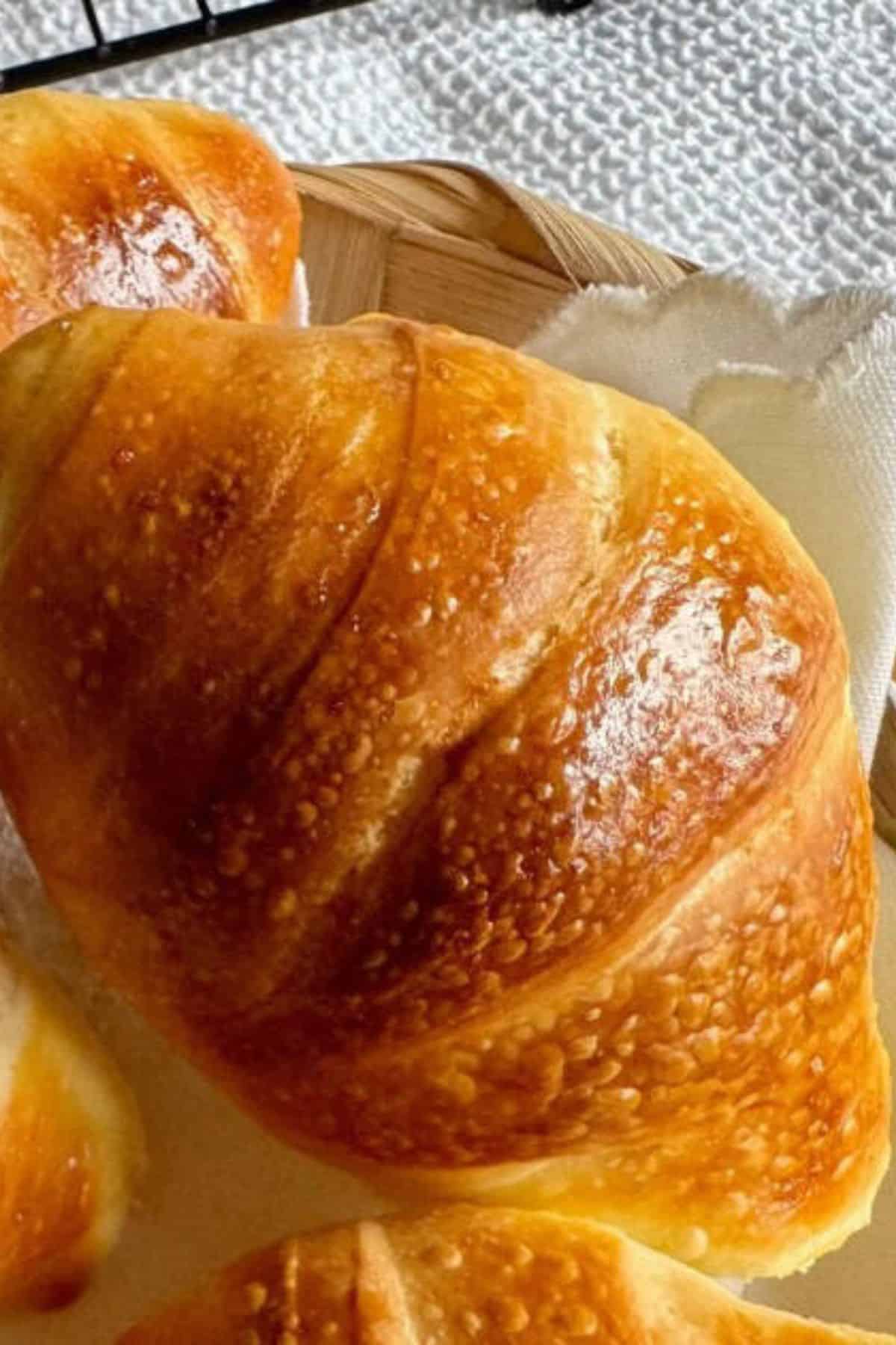 Close-up of sourdough bread highlighting its golden, crisp crust with detailed texture.