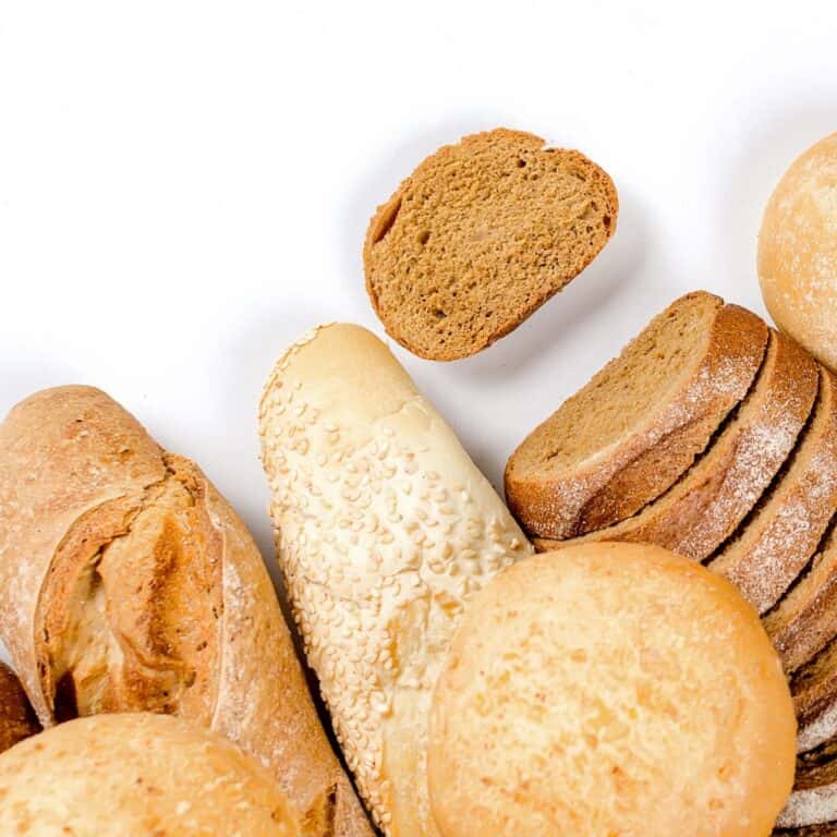 A display of sourdough breads with a wheat bread placed to the side.