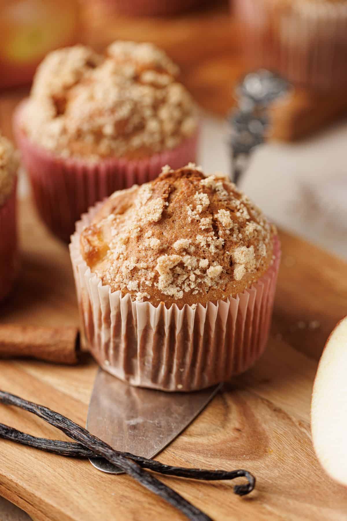 Close-up of an apple muffin with a cake server positioned next to it.