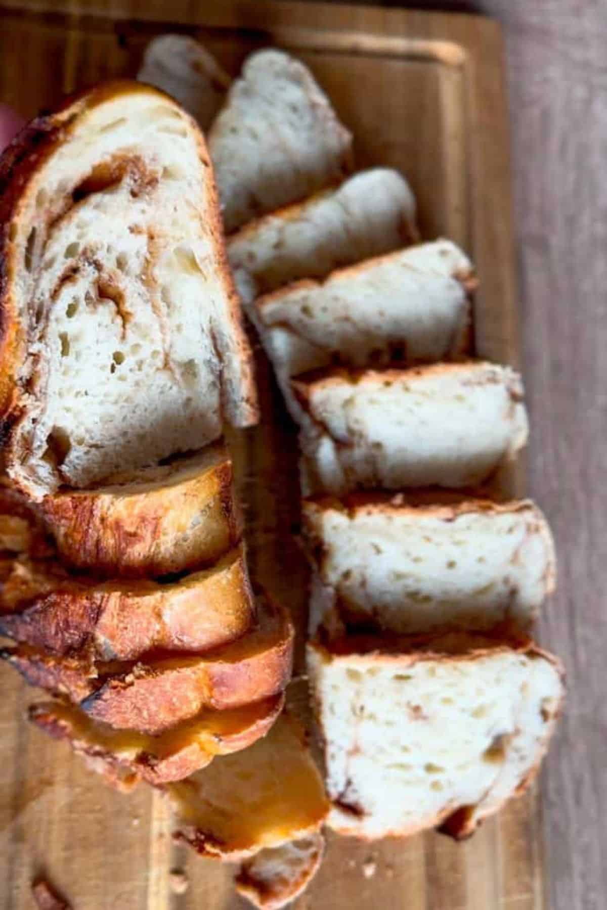 A loaf of bread being sliced with a knife, showing the texture of the crumb inside.
