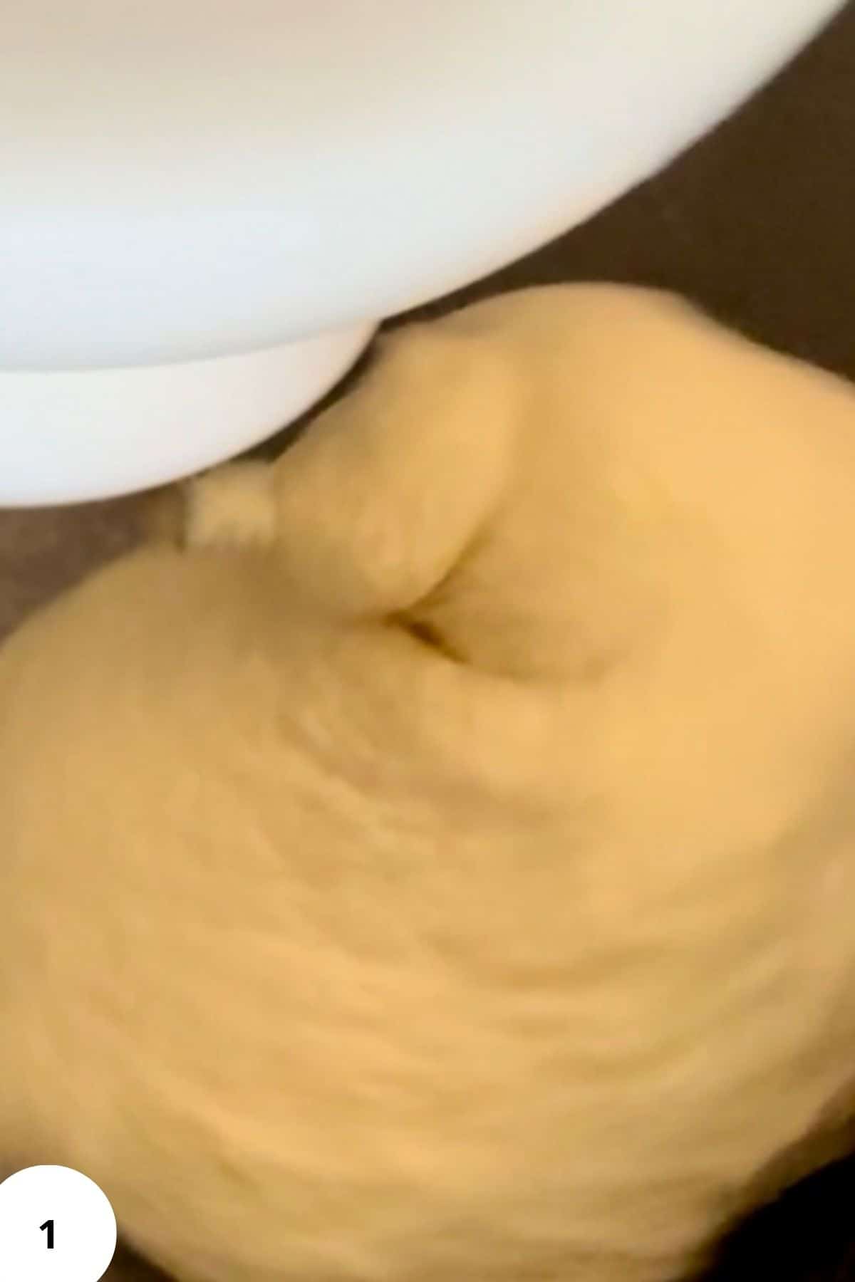 A stand mixer blending flour, egg, oil, and water into a soft dough for cherry strudel.