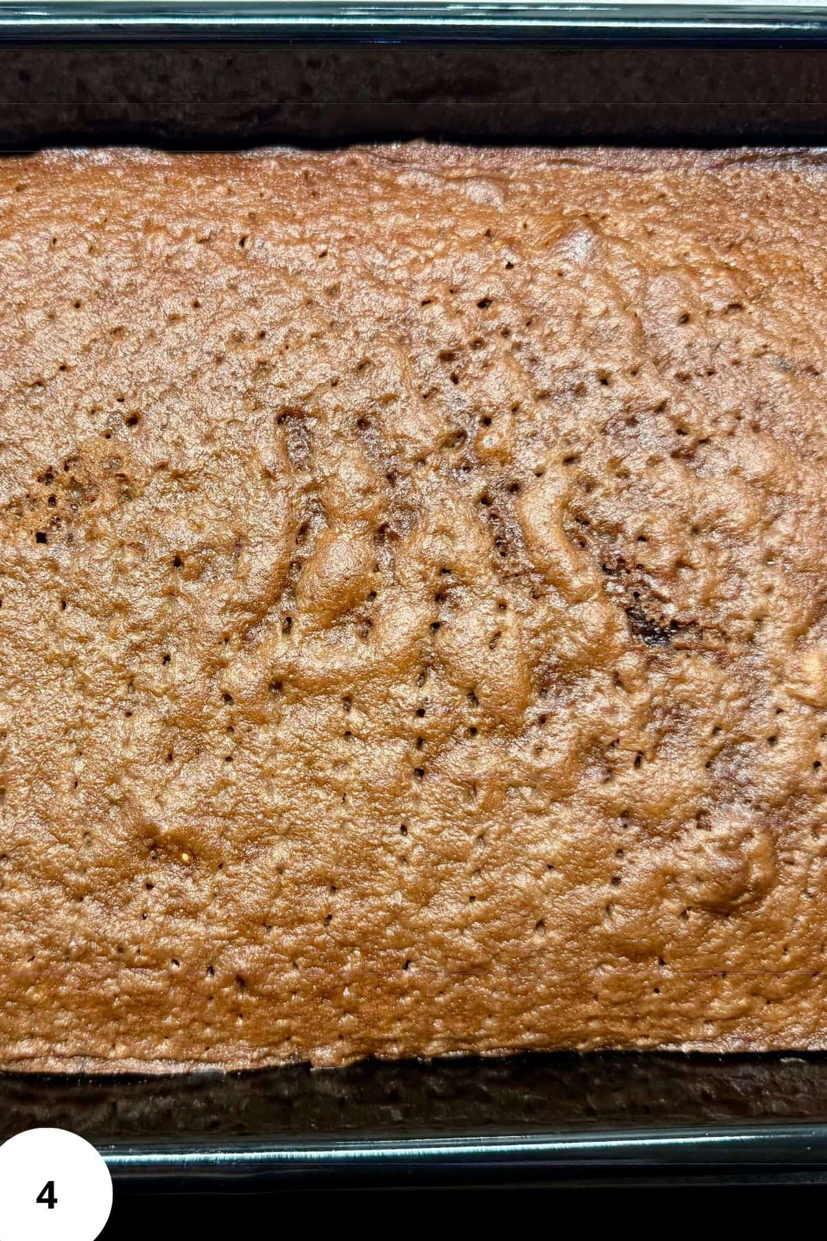 Freshly baked brown chocolate sponge cake in a rectangular pan.