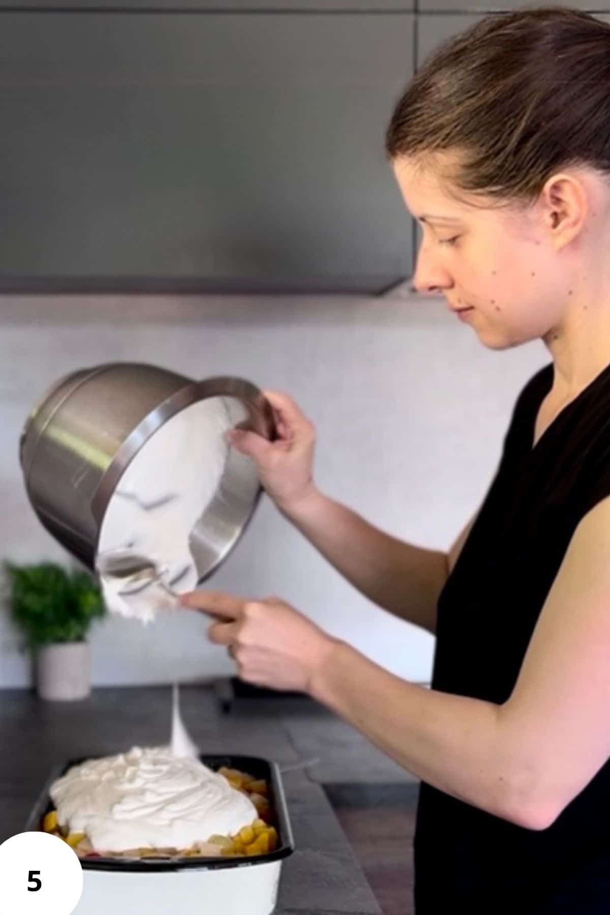 A person pouring the white chocolate glaze into a bowl, creating a smooth, glossy stream.