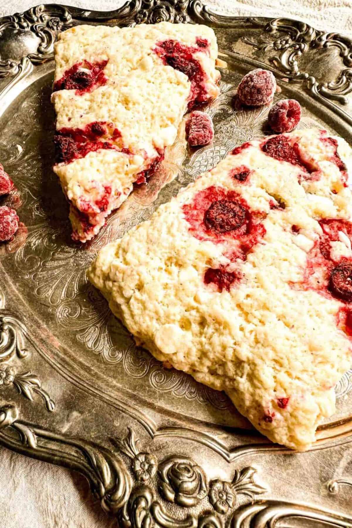 Raspberry and white chocolate sourdough scones served on a plate.