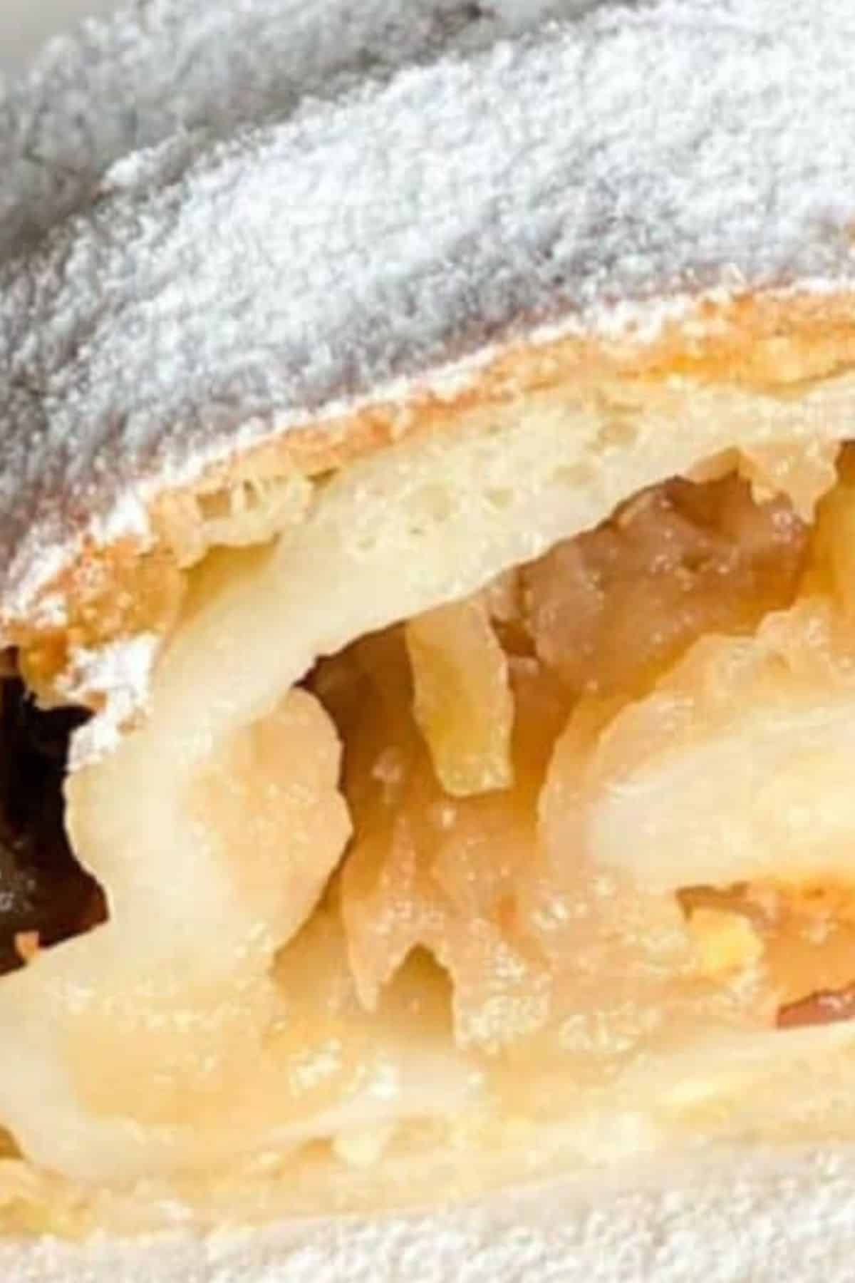 Close-up of apple strudel sliced open to show the spiced apple filling inside.