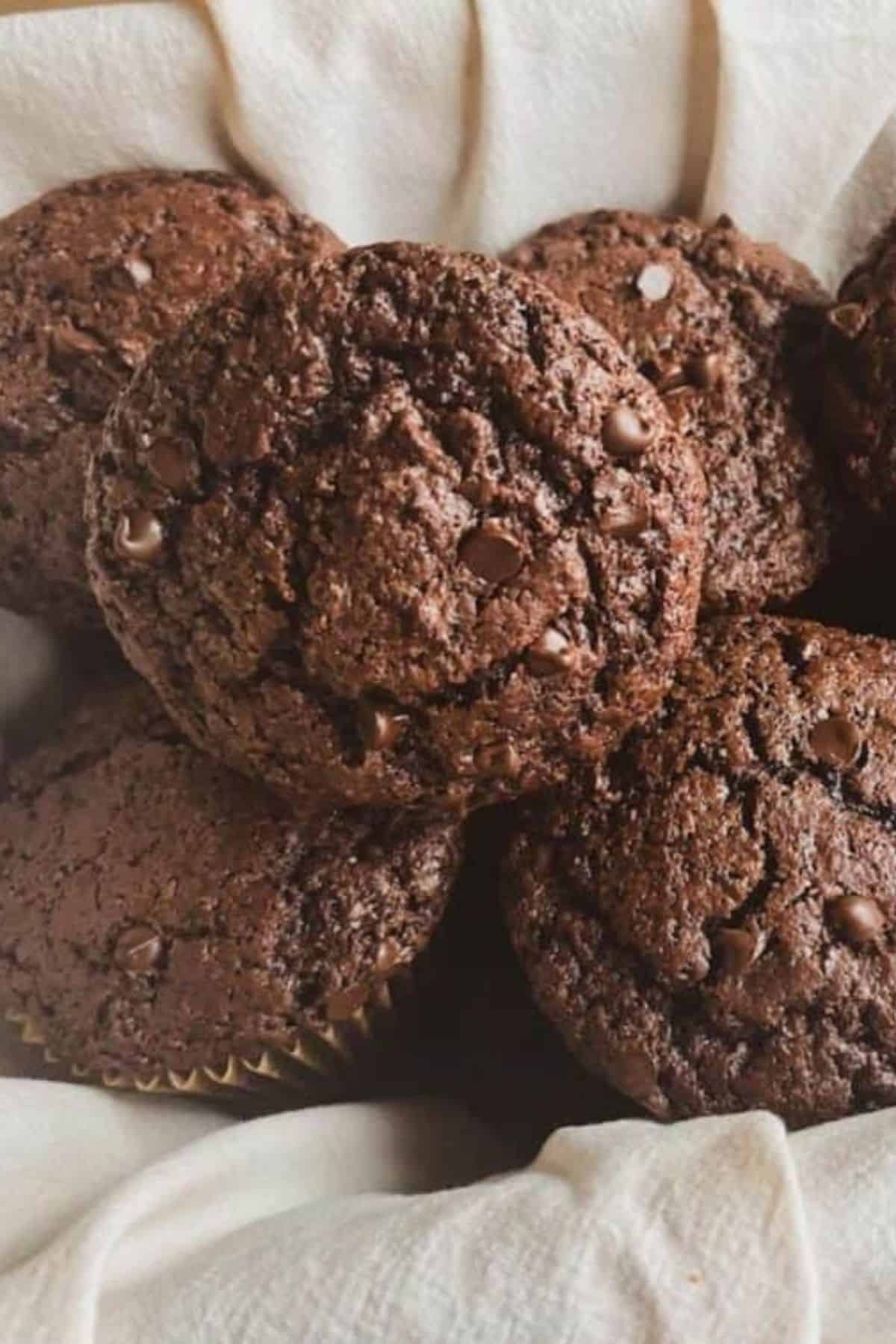 Close-up of chocolate sourdough muffins in a basket lined with cloth.