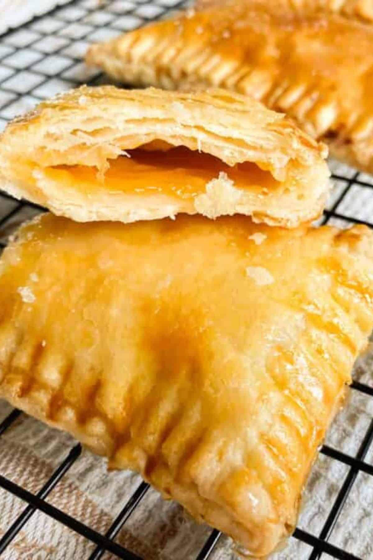Close-up of a sourdough discard pop tart with a bite taken out, showing the filling inside; placed on top of another whole pop tart.