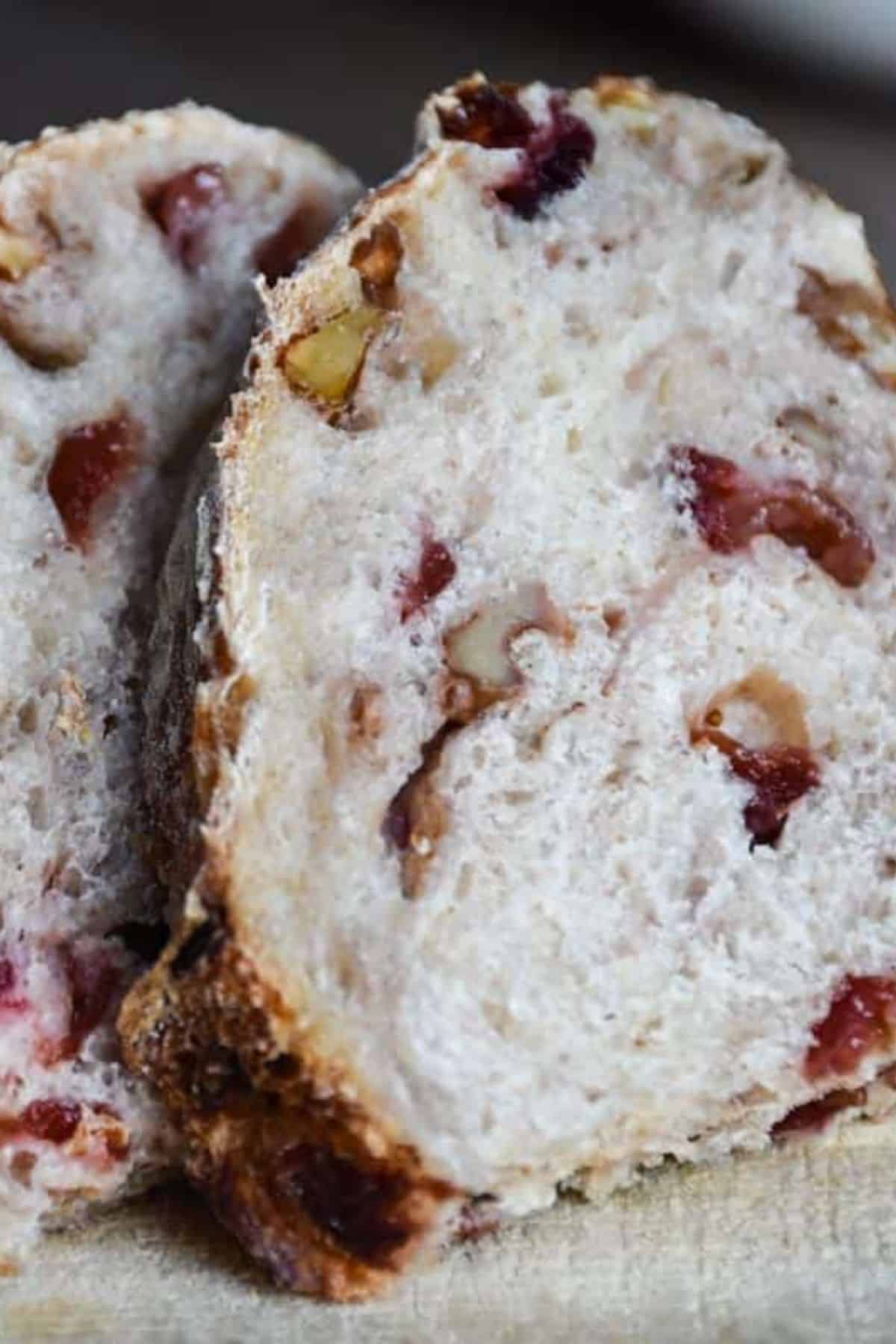 Slice of bread showing cranberries inside the soft, airy crumb.