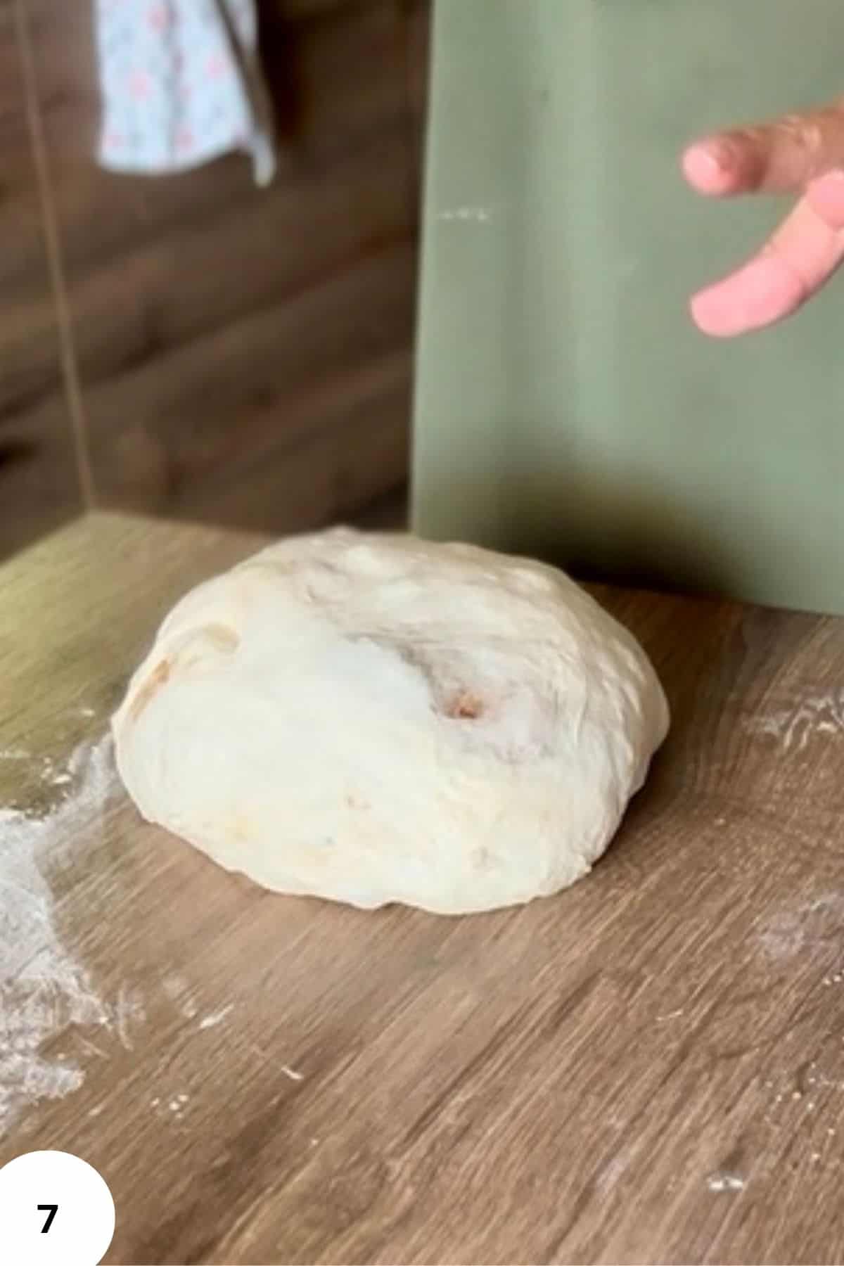 Dough resting on a floured surface, ready to be shaped or kneaded.