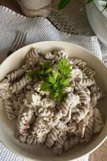 Pasta with sauce and chicken served on a plate.