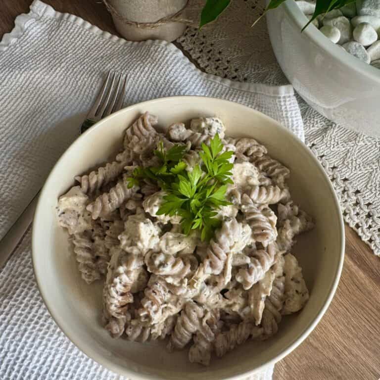 Pasta with sauce and chicken served on a plate.