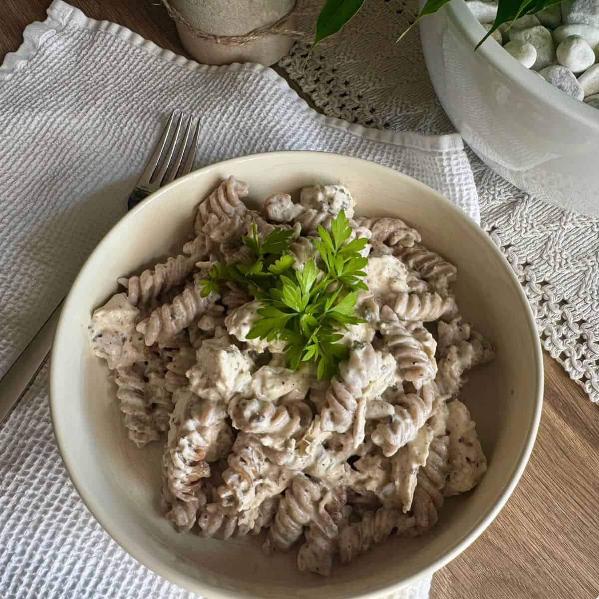 Pasta with sauce and chicken served on a plate.