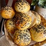 Freshly baked burger buns being stacked on top of each other.