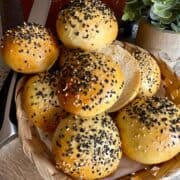 Freshly baked burger buns being stacked on top of each other.