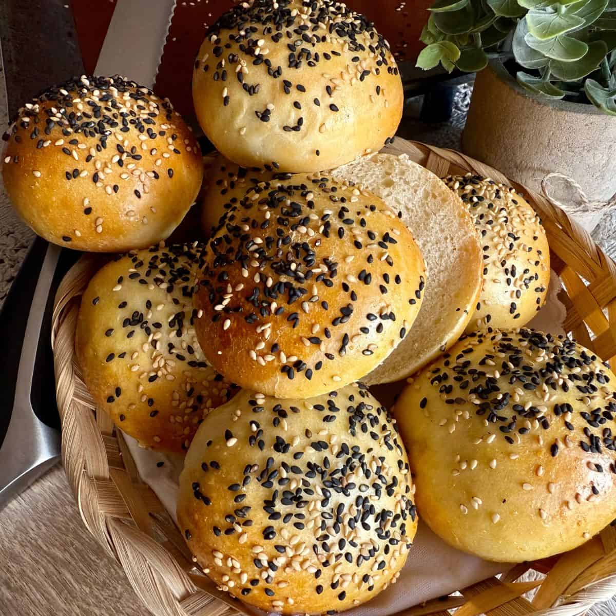 Freshly baked burger buns being stacked on top of each other.
