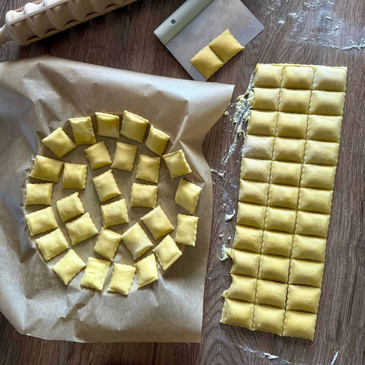 Ravioli arranged in a single layer on a parchment-lined tray.