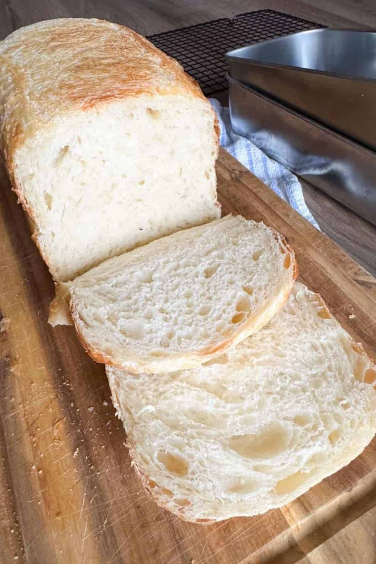 Sliced Tangzhong sourdough sandwich bread arranged on a wooden board, revealing a soft and fluffy crumb.