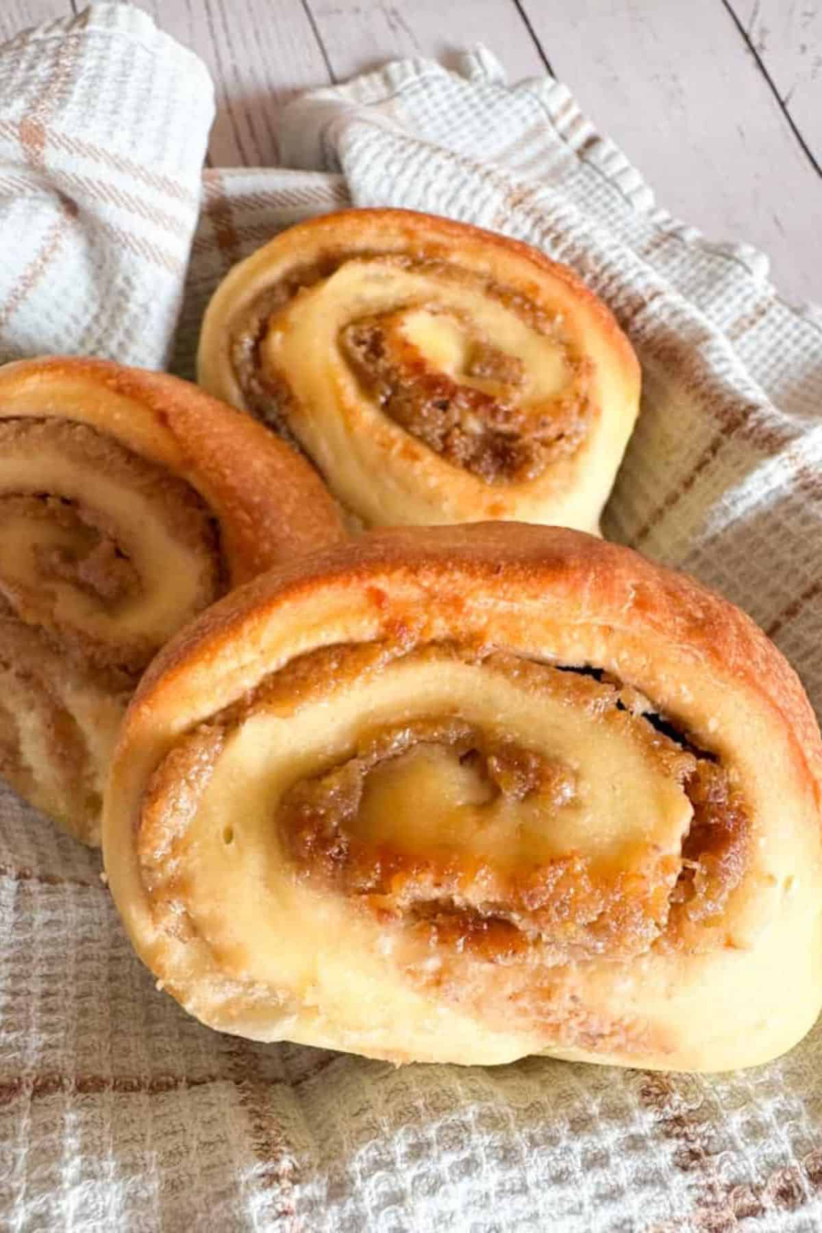 Mini sourdough walnut rolls nestled in a soft cloth, showing their golden-brown crust and nutty texture.
