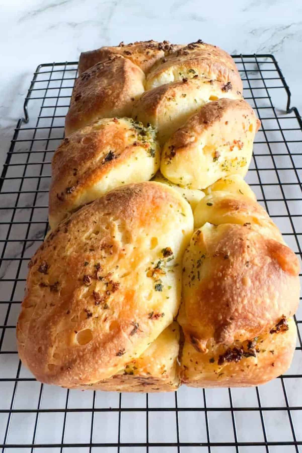 Sourdough pull-apart garlic bread cooling on a wire rack.
