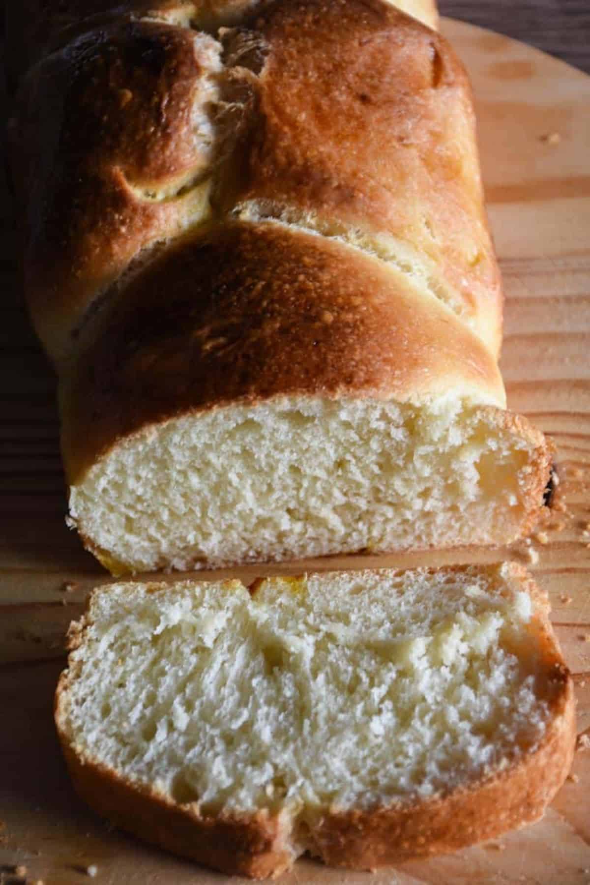 Sliced sourdough brioche bread arranged on a wooden board, revealing its soft and fluffy texture.