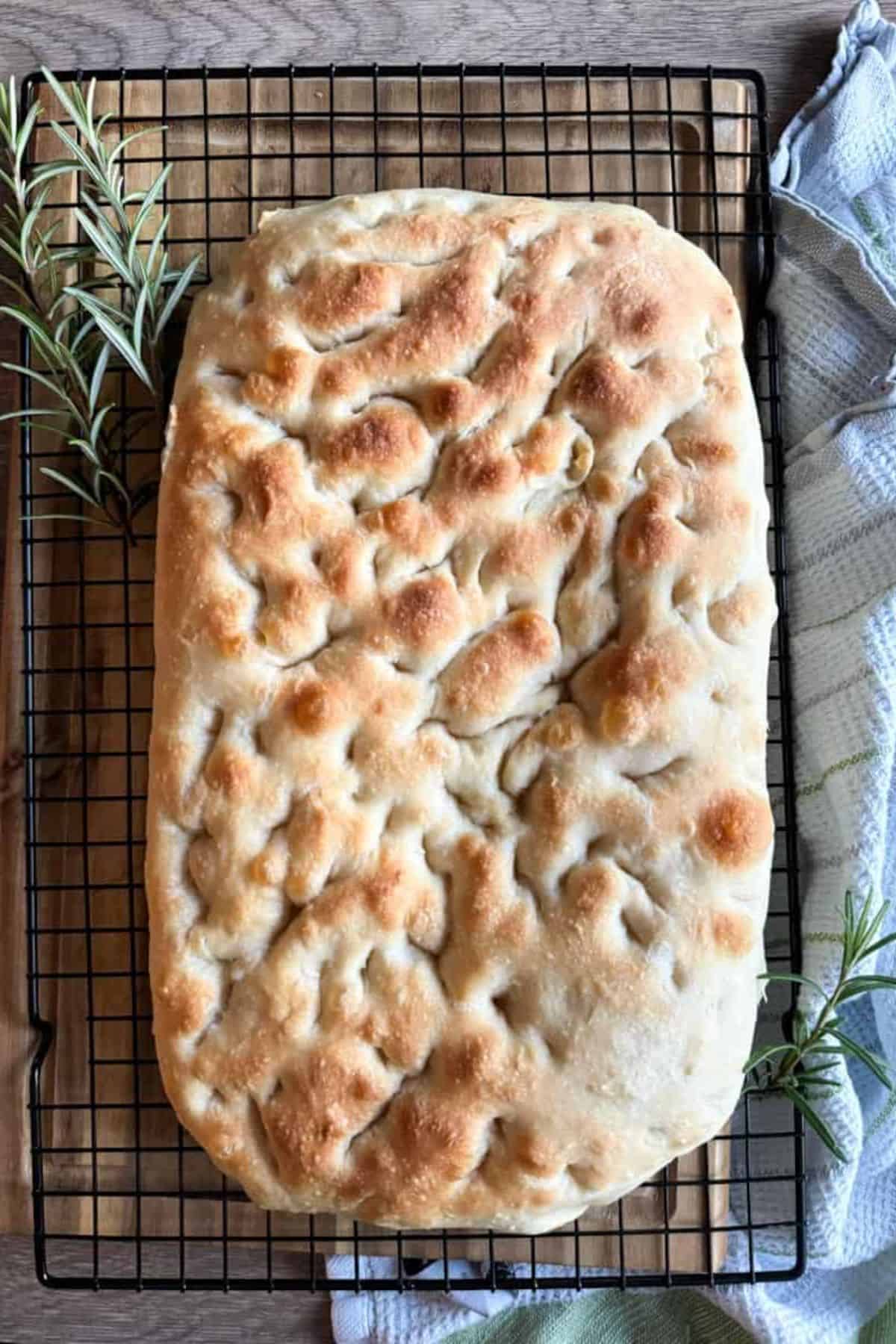 Focaccia bread resting on a cooling rack.